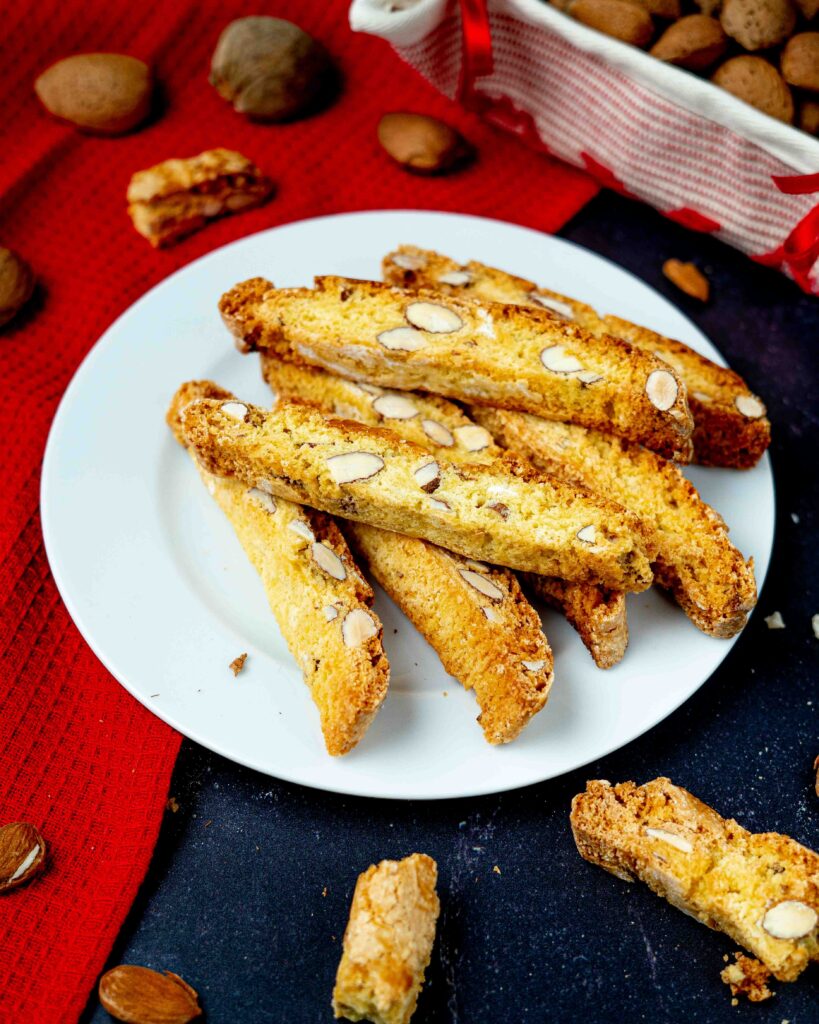 Biscotti del prato con mandorle nel piatto bianco e mandorle sul tavolo