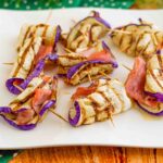 piatto di involtini nello stecchino di melanzane e prosciutto su piatto bianco