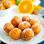 piatto con brugnoli di ricotta arancia e grattugia sul tavolo