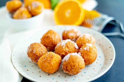piatto con brugnoli di ricotta arancia e grattugia sul tavolo