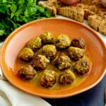polpette allo zafferano in piatto con prezzemolo cipolle e mestoli