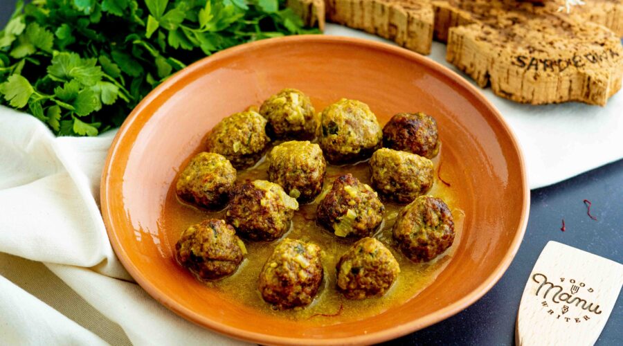 polpette allo zafferano in piatto con prezzemolo cipolle e mestoli