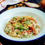 piatto binaco con pasta e strofinaccio cipolla nel tavolo nero e noci aperte