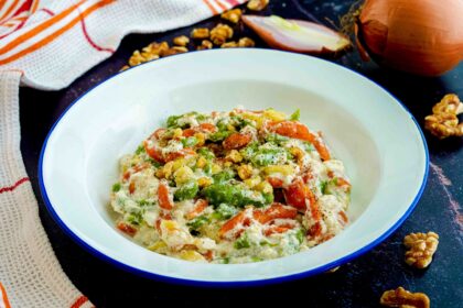 piatto binaco con pasta e strofinaccio cipolla nel tavolo nero e noci aperte