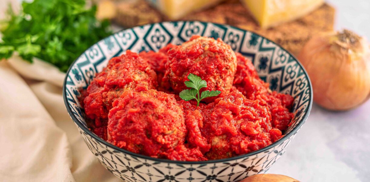 polpette in ciottola con formaggio e cipolle con prezzemolo sul tavolo