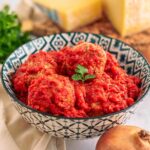 polpette in ciottola con formaggio e cipolle con prezzemolo sul tavolo