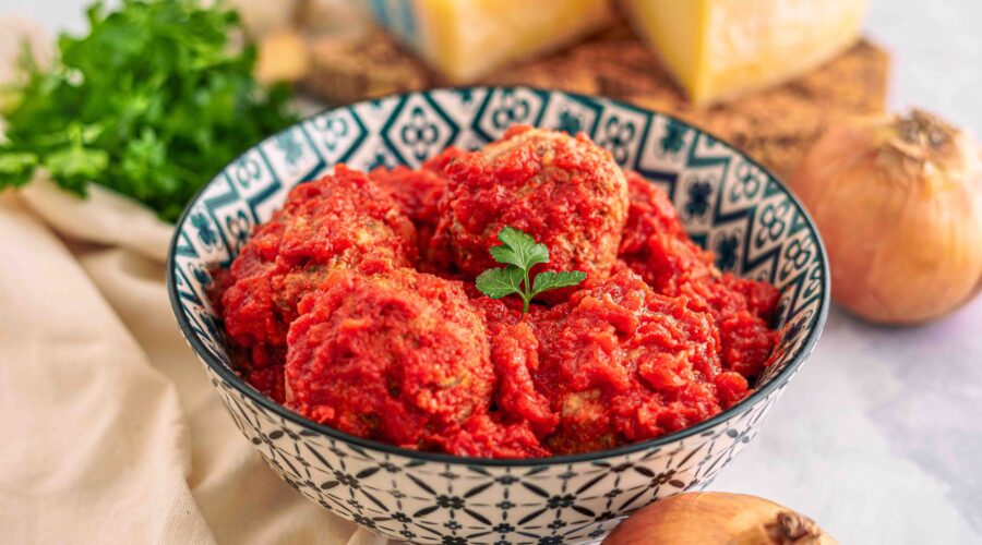 polpette in ciottola con formaggio e cipolle con prezzemolo sul tavolo