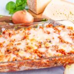 Teglia di fregola tipica sarda con formaggi sul tagliere basilico e cipolla