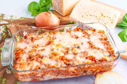 Teglia di fregola tipica sarda con formaggi sul tagliere basilico e cipolla