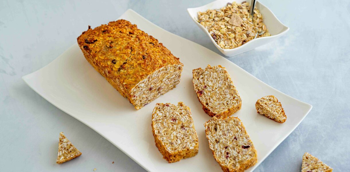 pluumcake sul piatto con pezzi di cereali e ciottola con muesli