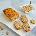 pluumcake sul piatto con pezzi di cereali e ciottola con muesli