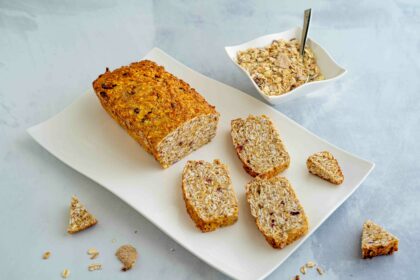 pluumcake sul piatto con pezzi di cereali e ciottola con muesli