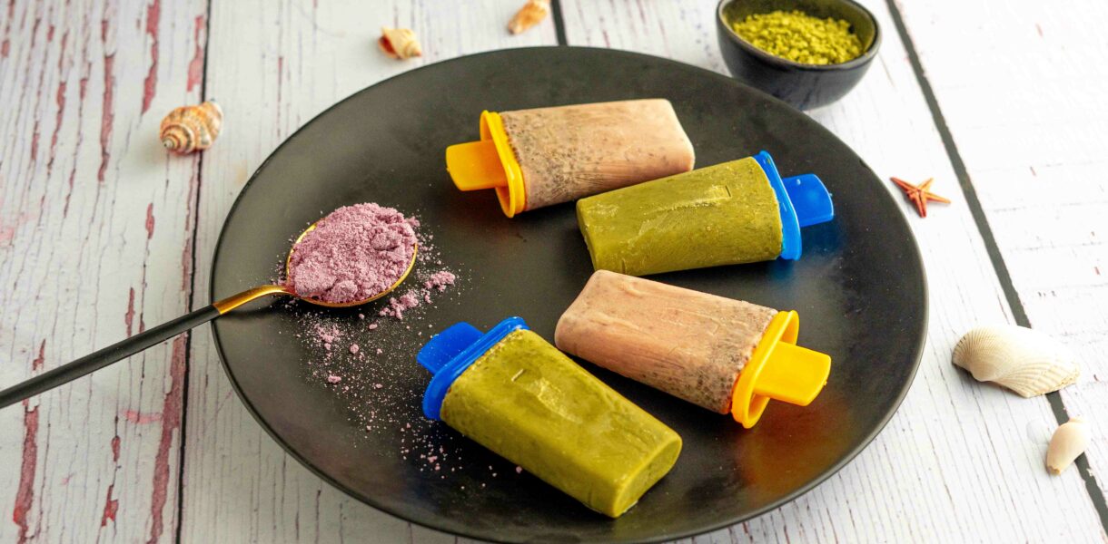 piatto nero con 4 ghiaccioli cucchiaio con taro, sul tavolo conchiglie e ciotola con matcha