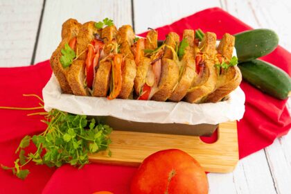pane al forno nel contenitore sul tagliere sul tavolo zucchine pomodoro e prezzemolo