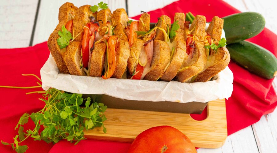 pane al forno nel contenitore sul tagliere sul tavolo zucchine pomodoro e prezzemolo