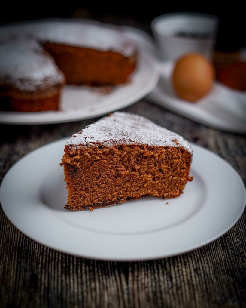 fetta di torta in primo piano e dietro torta tagliata