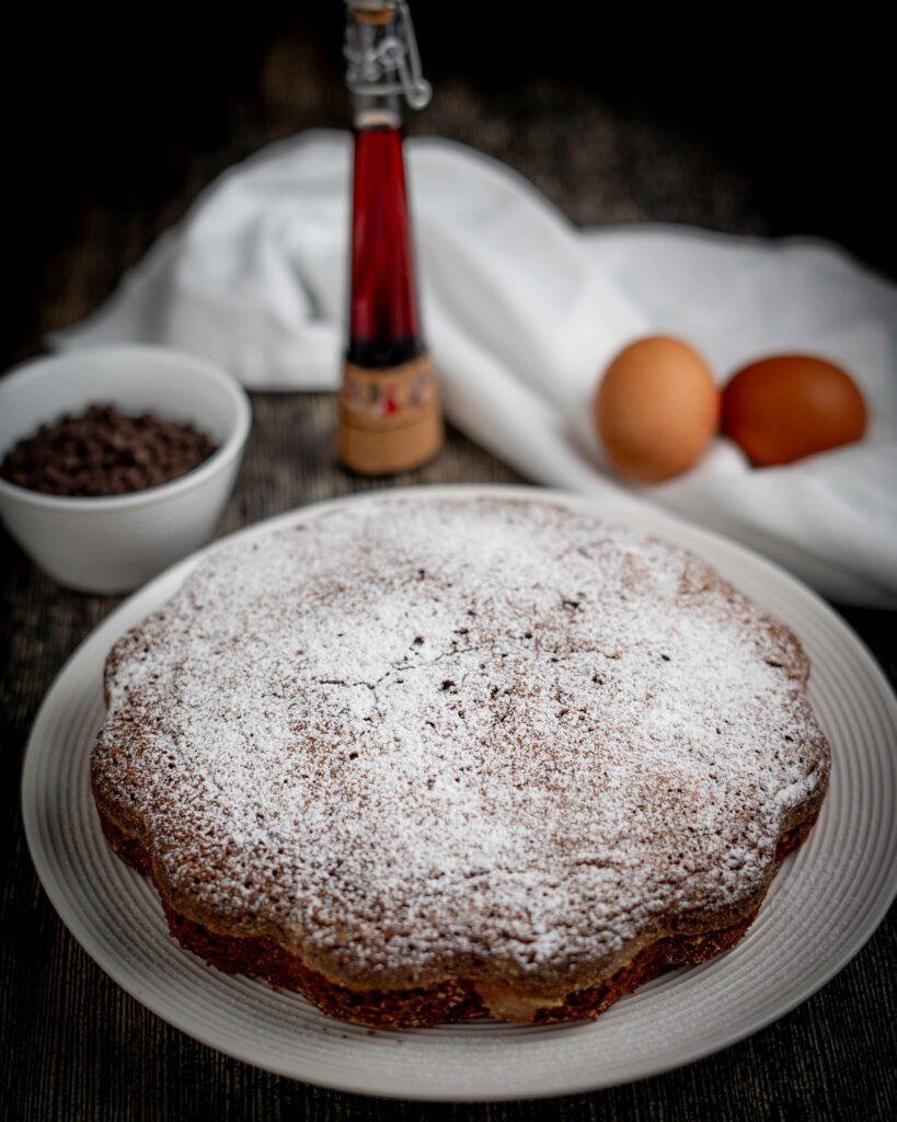 foto torta nel piatto con zucchero a velo sul tavolo ciottola di gocce e uova