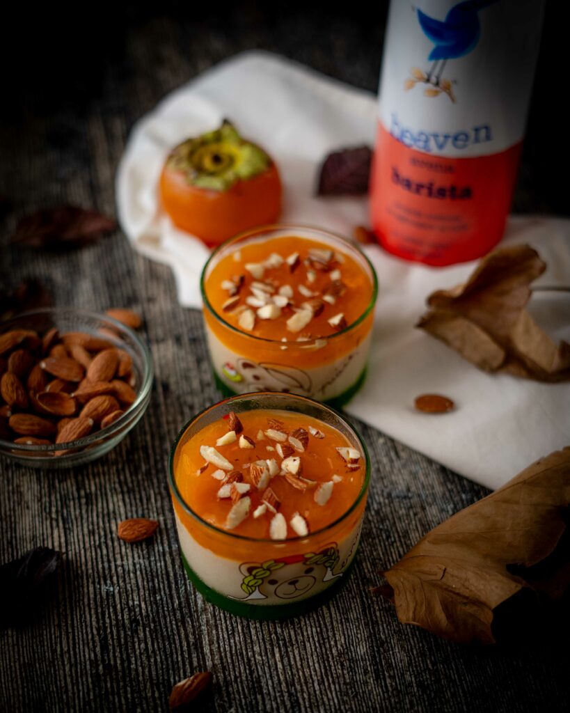 budino sui bicchieri con mandorle sul tavolo foglie autunnali ciottola con mandorle e bottiglia di latte