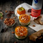 budino sui bicchieri con mandorle sul tavolo foglie autunnali ciottola con mandorle e bottiglia di latte