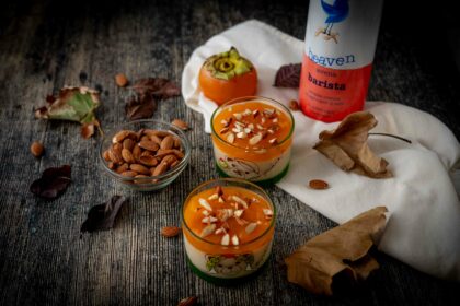 budino sui bicchieri con mandorle sul tavolo foglie autunnali ciottola con mandorle e bottiglia di latte