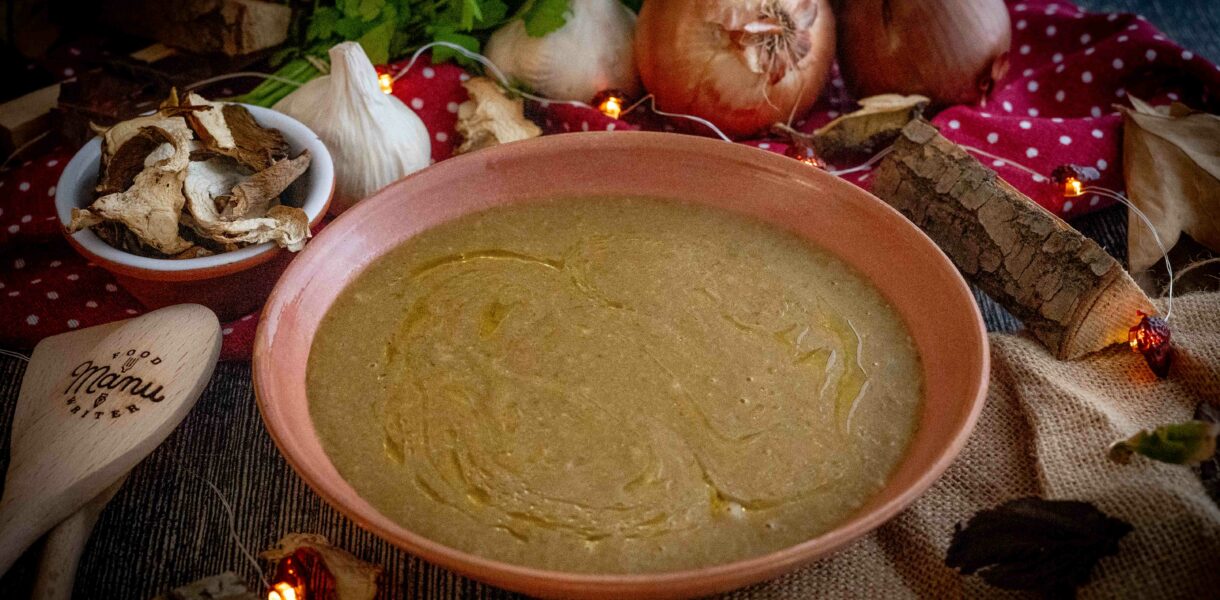 crema ai funghi nel piatto con cipolla e fughi sul tavolo