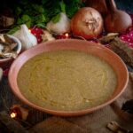 crema ai funghi nel piatto con cipolla e fughi sul tavolo