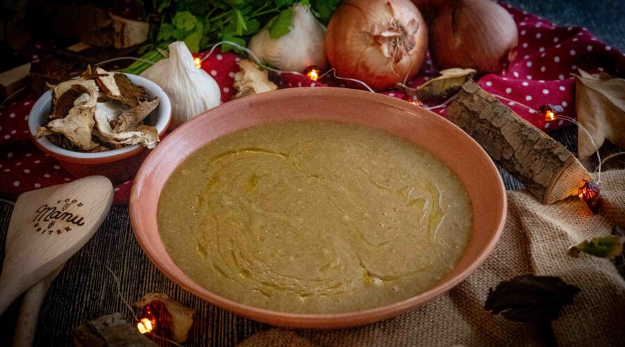 crema ai funghi nel piatto con cipolla e fughi sul tavolo