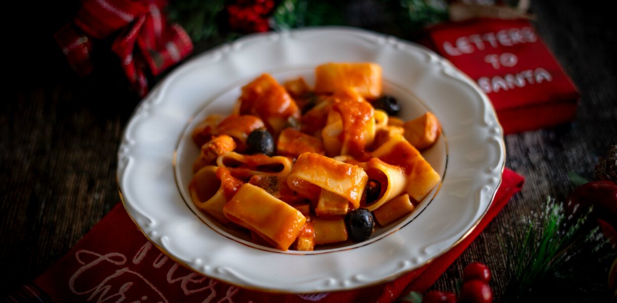 piatto bianco con pasta e sul tavolo decorazioni natalizie