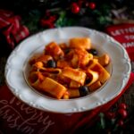 piatto bianco con pasta e sul tavolo decorazioni natalizie