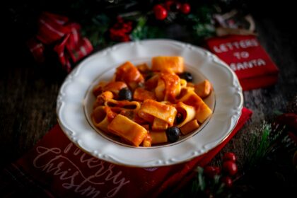 piatto bianco con pasta e sul tavolo decorazioni natalizie