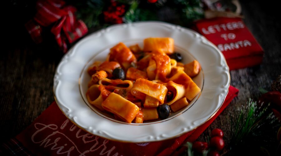 piatto bianco con pasta e sul tavolo decorazioni natalizie