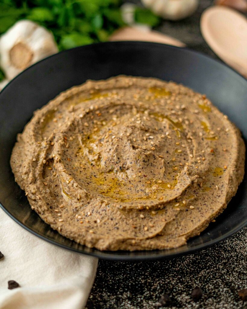 hummus in primo piano sul piatto nero