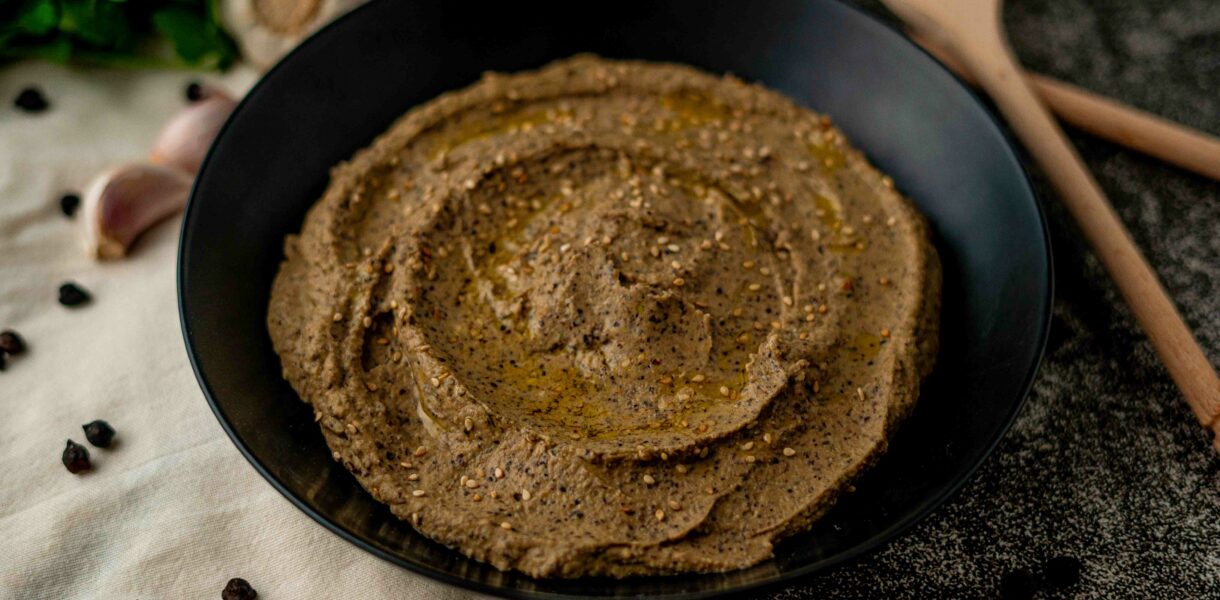piatto nero con hummus di ceci