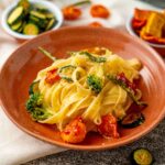 piatto di pasta con verdure disidratate in ciottola vicino sulos trofinaccio panna sul tavolo