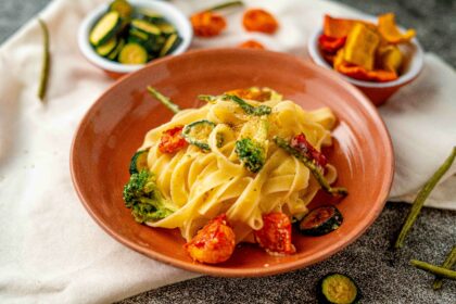 piatto di pasta con verdure disidratate in ciottola vicino sulos trofinaccio panna sul tavolo