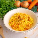risotto alle carote con nocciole in un piatto banco